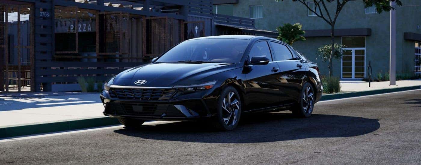 A black 2026 Hyundai Elantra parked next to a pizza shop.