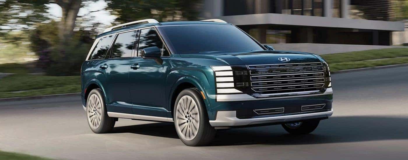 Emerald Green 2026 Hyundai Palisade driving on a paved road.