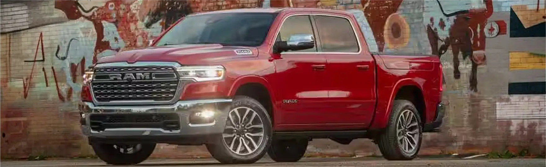 Red RAM 1500 crew cab parked in front of a large graffiti mural