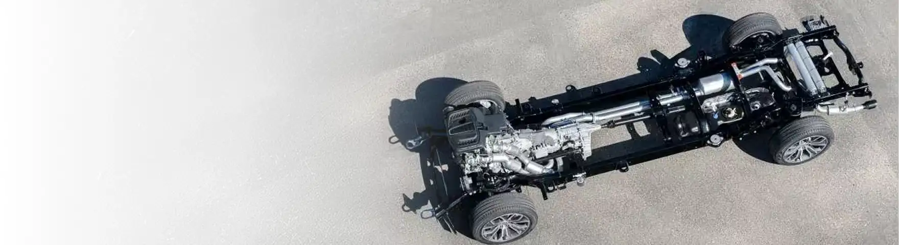 Overhead view of the RAM 1500 steel frame, driveline and suspension on a gray floor