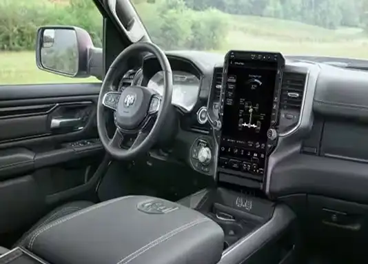 Driver-side view of the RAM 1500 Rebel cabin showing the touchscreen, side mirror and black leather-trimmed seats