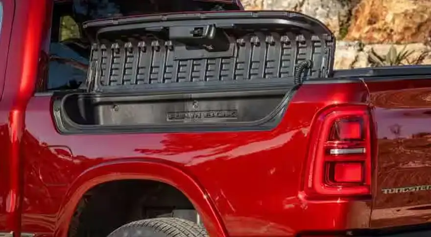 Open RamBox cargo compartment built into the bed rail of a red RAM 1500