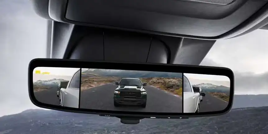 Digital rearview mirror streaming the road behind a RAM 1500 towing a trailer
