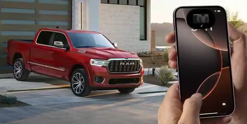 Person holding a smartphone running the RAM app with a red RAM 1500 parked behind them