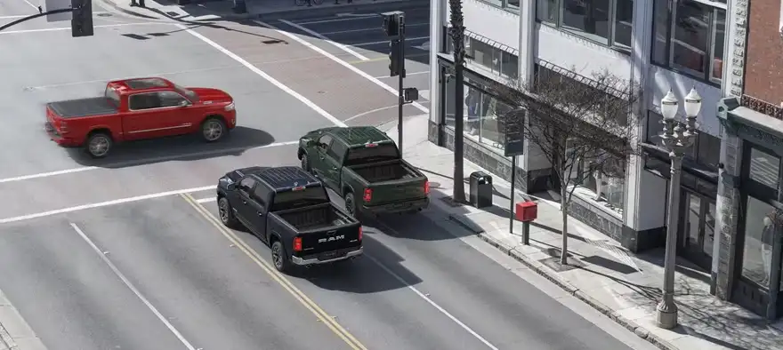 Overhead illustration of a black RAM 1500 stopping as a red pickup crosses a city intersection