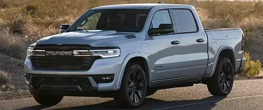 Silver RAM 1500 crew cab parked in dry grassland at sunset, front three-quarter view