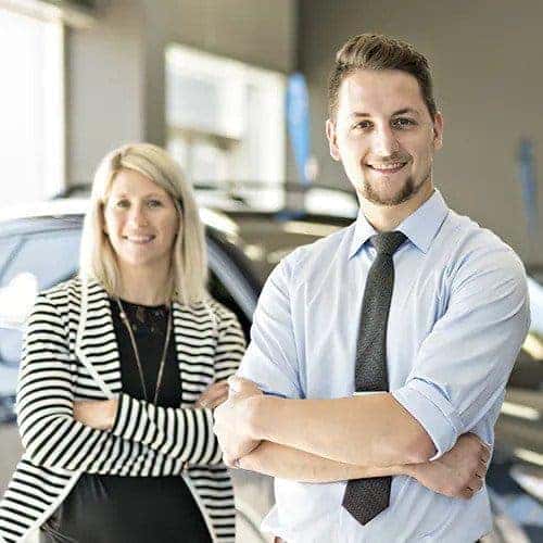 Man and woman crossing their arms and smiling