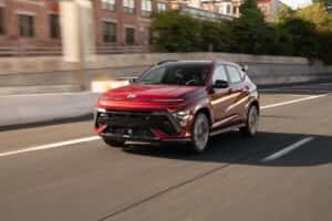 red hyundai kona driving down road with blurred background