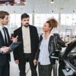 Man-in-Blue-Business-Suit-Talking-to-Woman-Touching-the-Car