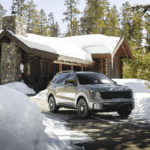 A car parked in front of a cabin in the snow