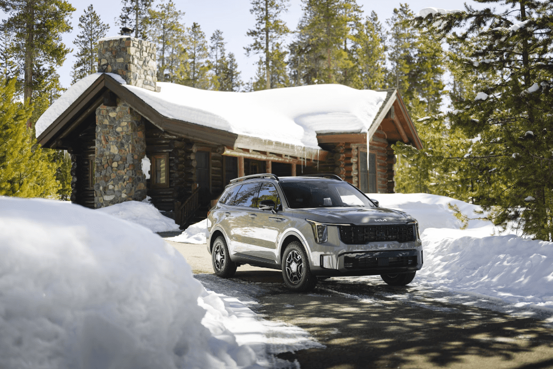 A car parked in front of a cabin in the snow