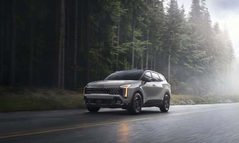 2026 Kia Sportage driving on forest road