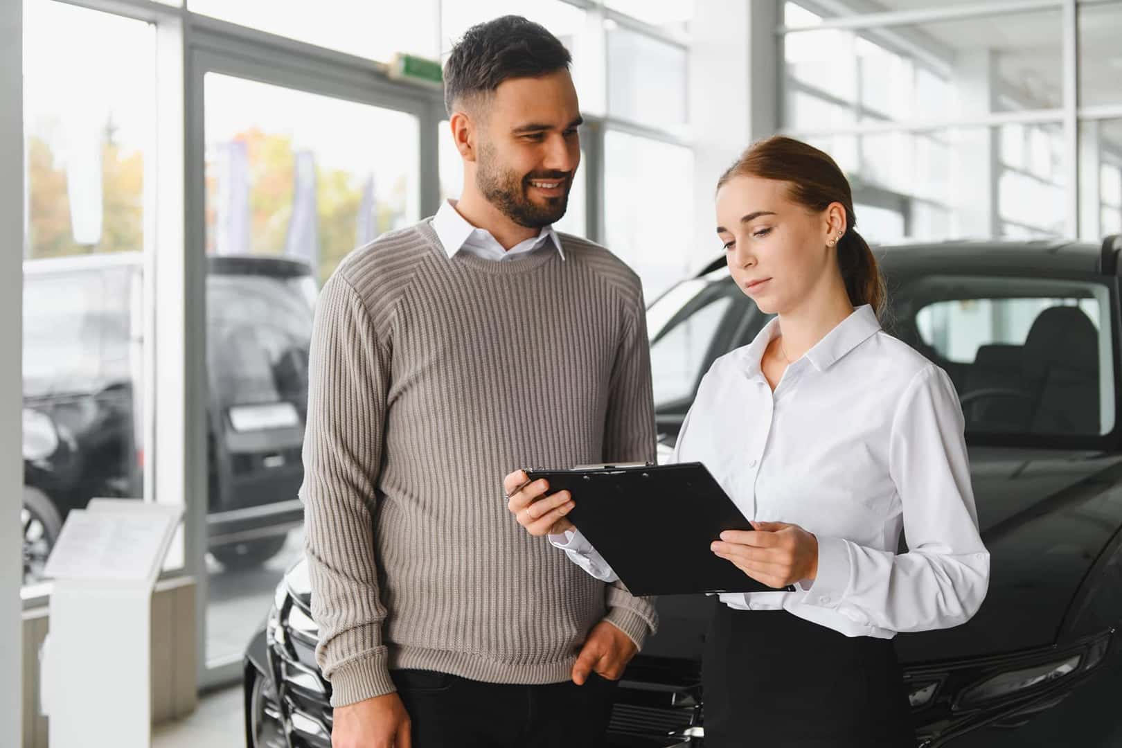 looking at paperwork at car dealership