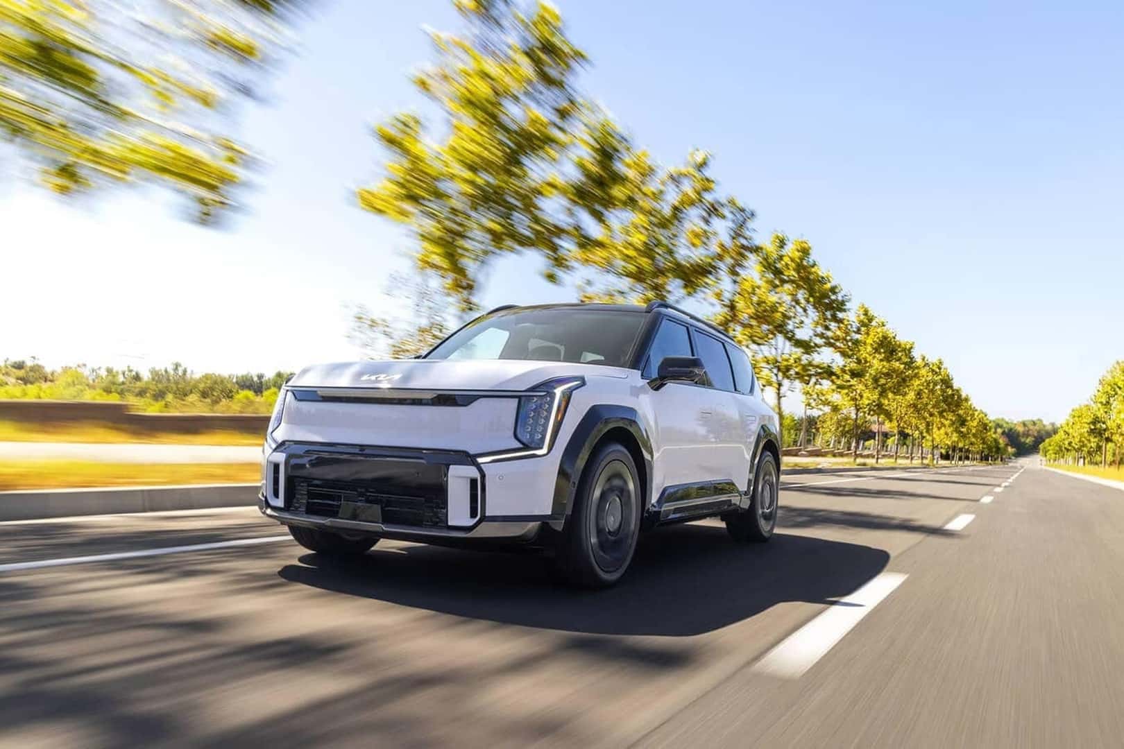 white 2026 ev9 driving on road