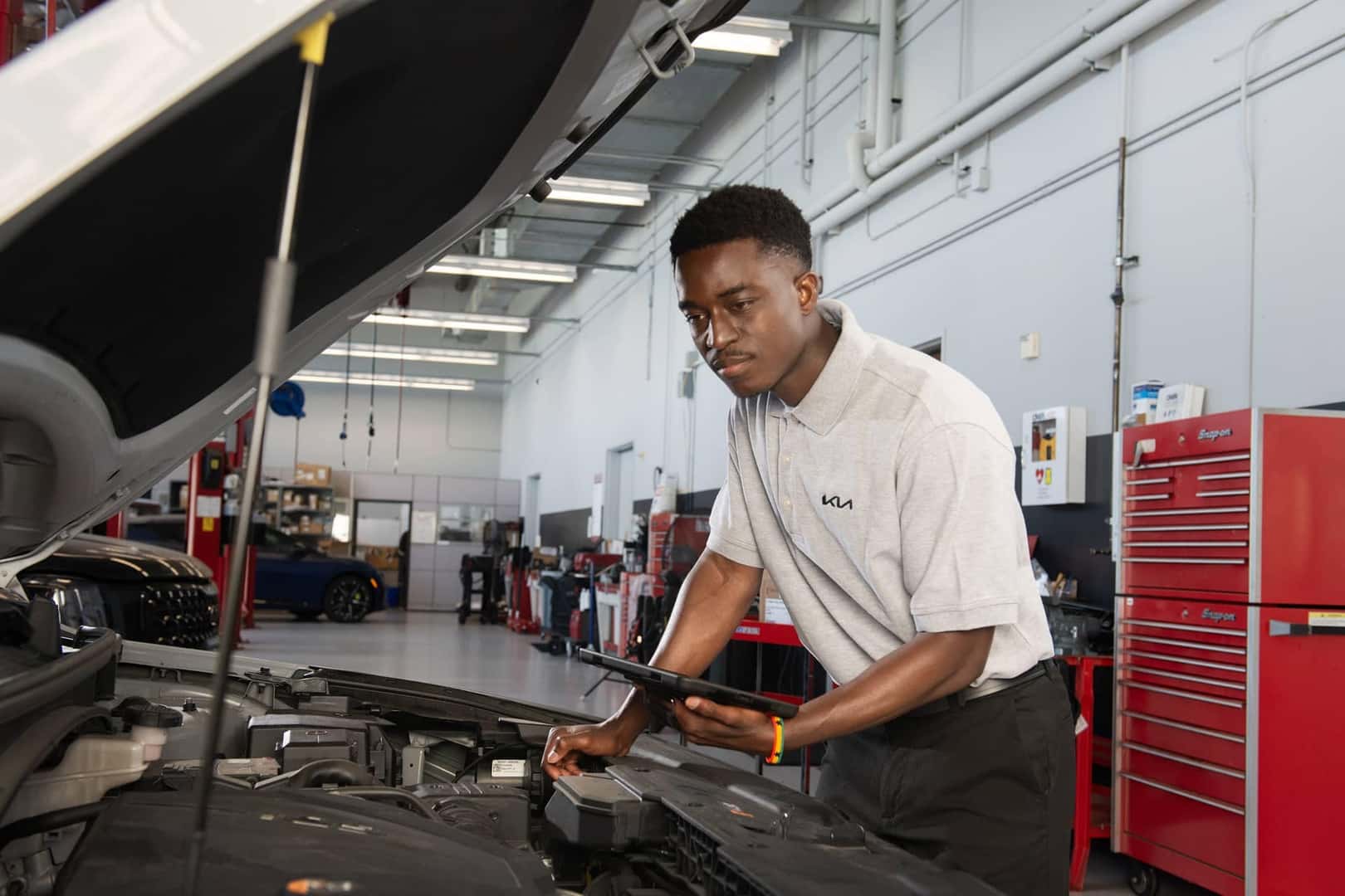 kia service technician inspecting vehicle