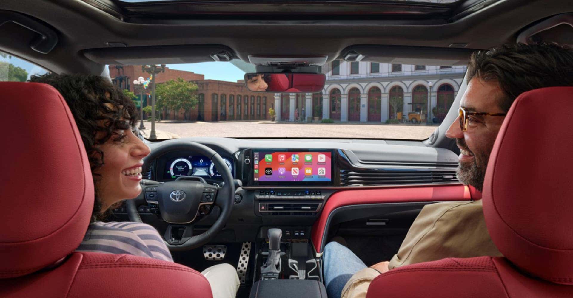 Back view of couple talking in camry with red interior