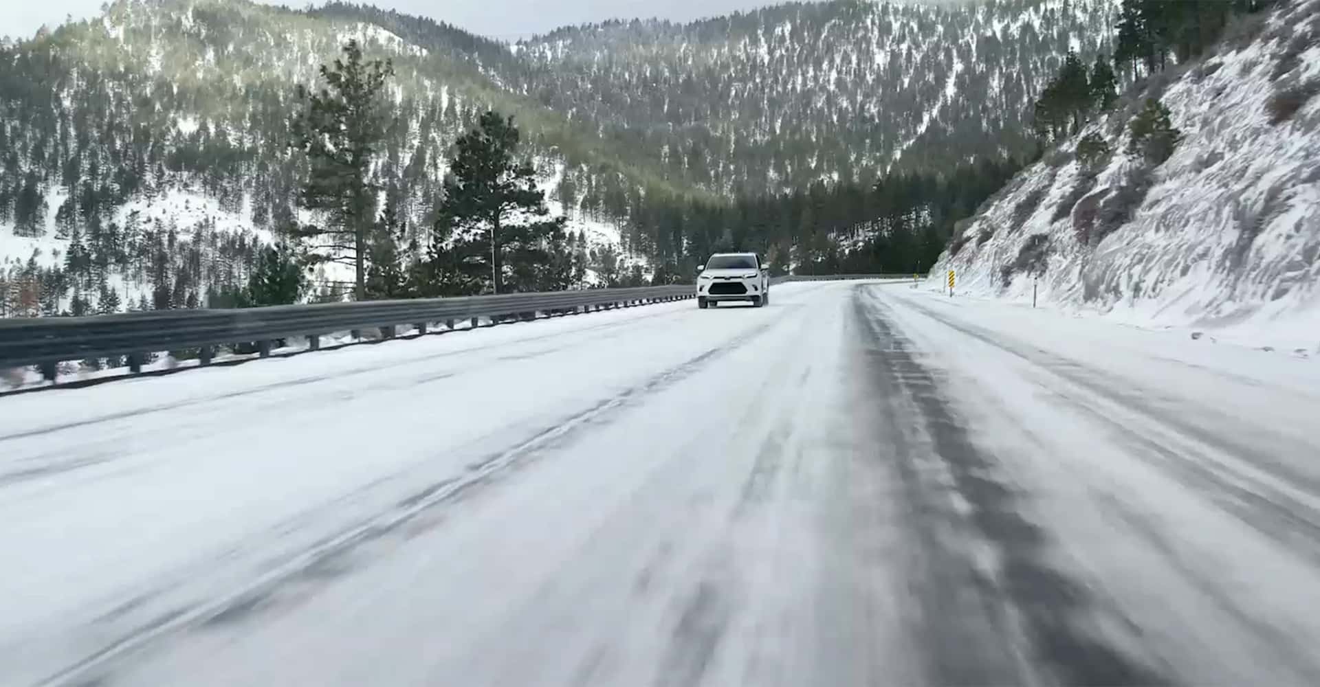 Far away shot of 2025 Grand Highlander driving in snow