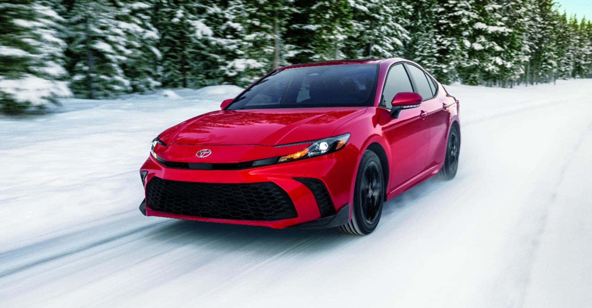 side view red camry in the snow
