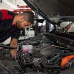 Toyota technician inspecting under hood of vehicle