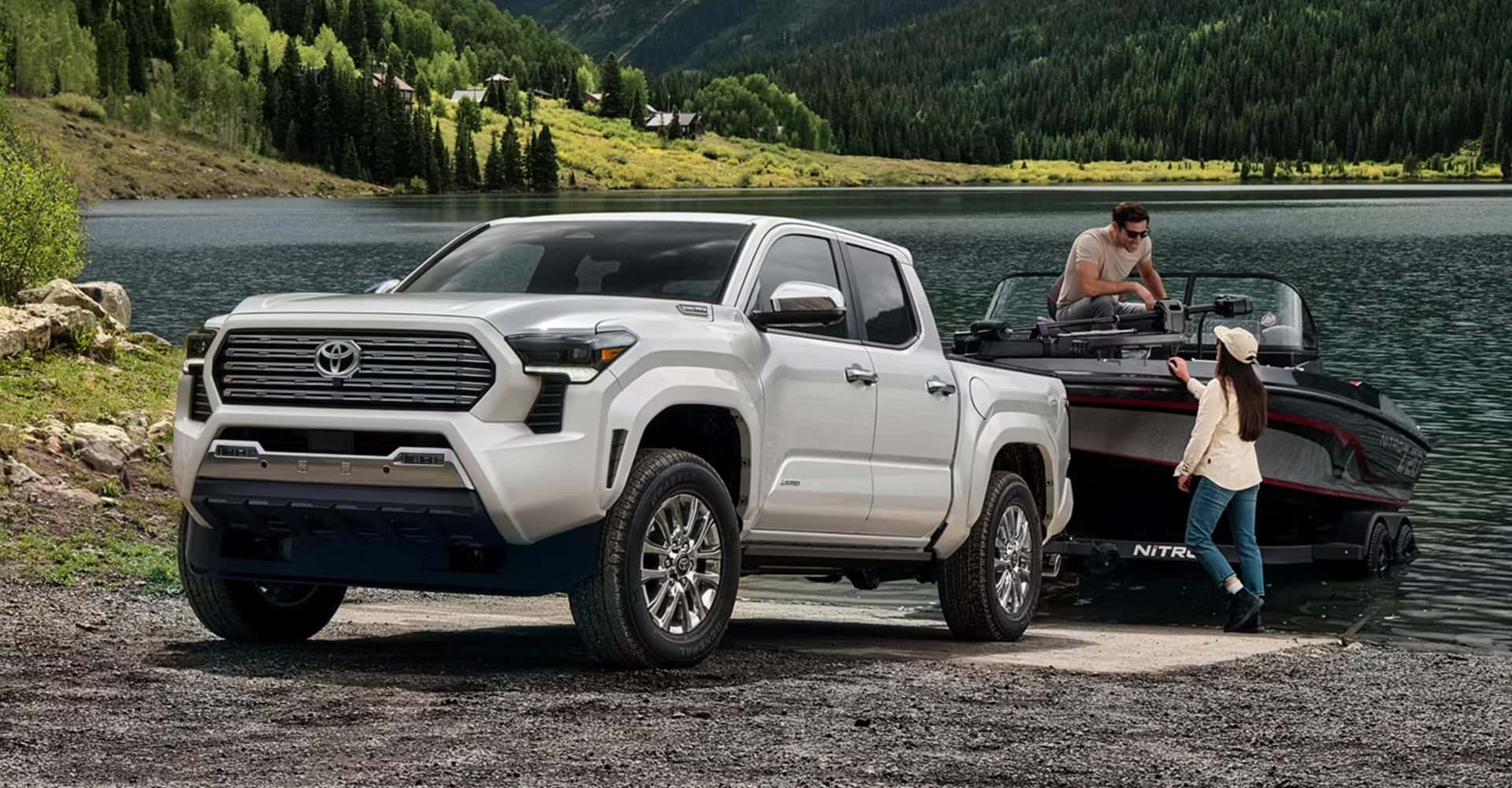 Couple unloading boat from trailer hooked to 2026 tacoma