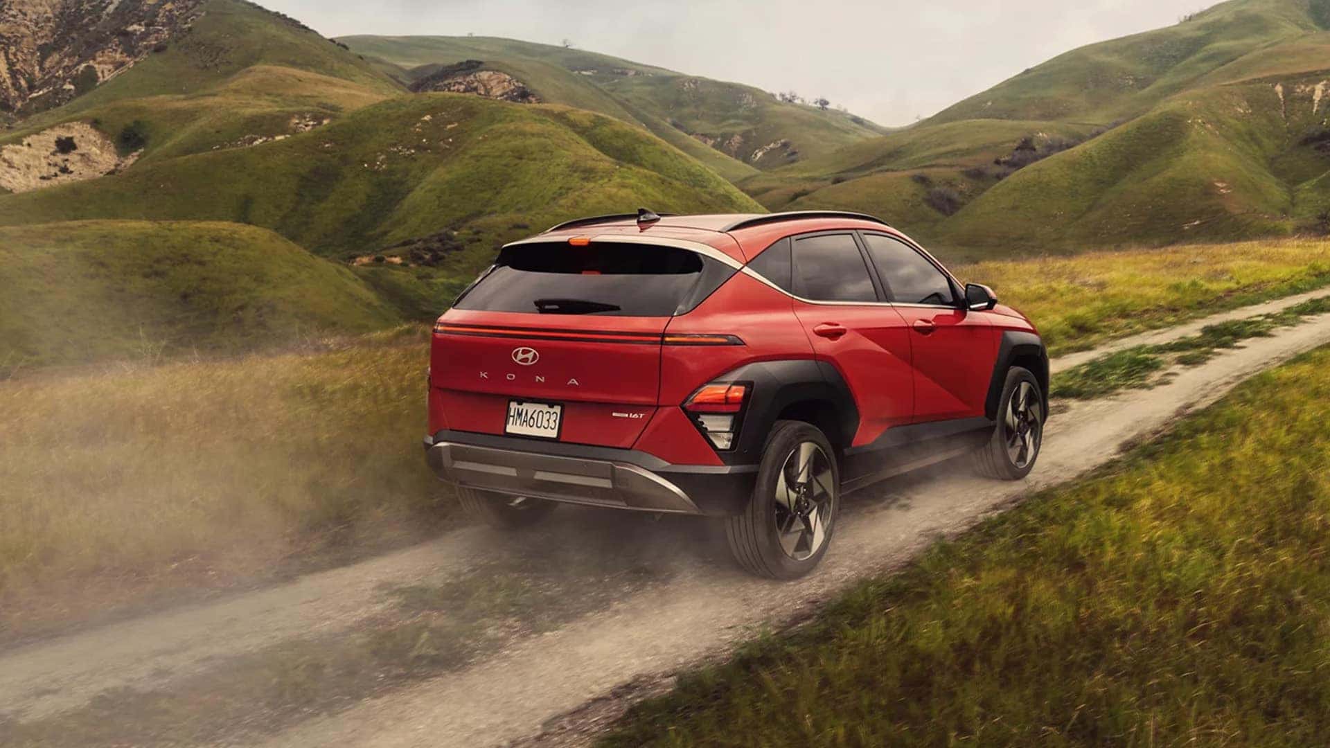 Back View of 2025 Kona Driving on Dirt Road
