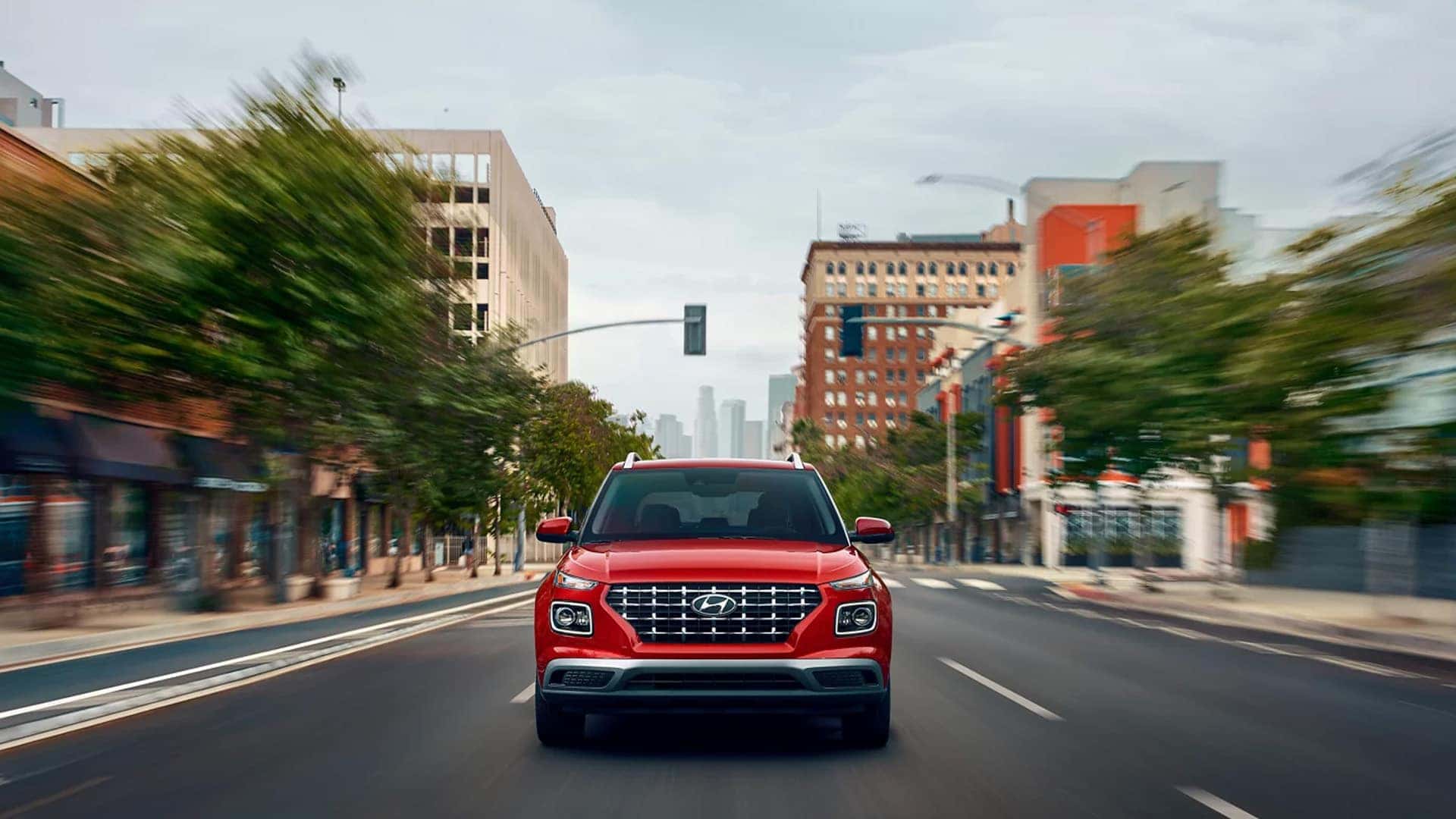 Front View of 2025 Hyundai Venue Driving Down City Street